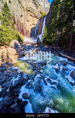 Yosemite Lower Falls al mattino presto con rocce gelate e fiume ghiacciato Foto Stock