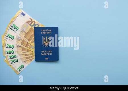 Passaporto dell'Ucraina, con banconote in euro su sfondo blu: Il concetto di denaro, assistenza sociale, viaggi, emigrazione, pagamenti sociali. Foto Stock