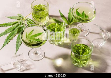 SBD canapa bere in vari bicchieri, fondo di cemento chiaro ombra dura, cocktail di energia cannabis Foto Stock