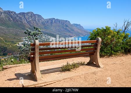 Rilassante luogo di riposo lungo un sentiero di montagna, con bellezza nella natura e pacifica armonia. Panca vuota su Table Mountain, Città del Capo, Sud Africa con Foto Stock