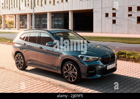 BMW X1 25e, ibrido, plug-in auto, parcheggiato accanto ad un edificio moderno. La potenza totale di entrambi i motori è 220hp. Autonomia elettrica fino a 52 km Katowice/Polan Foto Stock