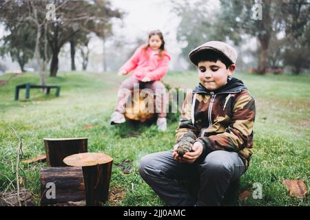 Due bambini che giocano in un parco giochi verde. Attività ricreative al parco. Foto Stock