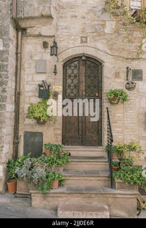 Porte doppie marroni su una villa italiana con vasi di fiori Foto Stock
