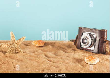 Sfondo di spiaggia con conchiglie, stelle marine e una fotocamera retrò Foto Stock