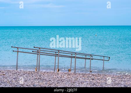 Disabili cromo metallo guardia rotaia acqua all'aperto mare struttura sfondo, concetto onde costa dalla protezione da corrimano di guardia, cormorano Foto Stock