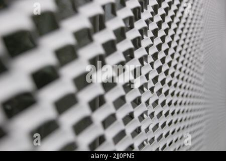 Primo piano di un pannello in metallo microforato con colori verdastri, struttura architettonica Foto Stock