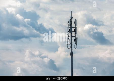 Torre trasmettitore rete cellulare su sfondo cielo nuvoloso, spazio copia Foto Stock