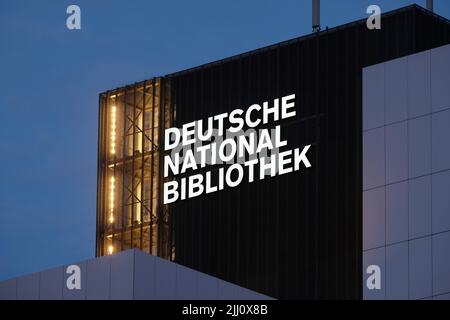 21 luglio 2022, Sassonia, Lipsia: La nuova scritta "Deutsche Nationalbibliothek" (DNB) brilla su un edificio alto 55 metri dell'ex biblioteca tedesca. Il logo da 7,7 x 3,2 metri è costituito da un corpo in alluminio verniciato e vetro acrilico illuminato da dietro. È montato sulla terza estensione dell'edificio DNB a Lipsia, il Bücherturm, inaugurato nel 1982. Una scritta identica deve ancora essere installata sul lato est del caricatore. La Biblioteca Nazionale tedesca, con sede a Lipsia e Francoforte sul meno, raccoglie tutto ciò che è stato pubblicato in lingua tedesca dal 1913. Foto: S Foto Stock