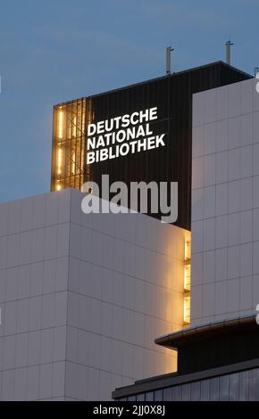 21 luglio 2022, Sassonia, Lipsia: La nuova scritta "Deutsche Nationalbibliothek" (DNB) brilla su un edificio alto 55 metri dell'ex biblioteca tedesca. Il logo da 7,7 x 3,2 metri è costituito da un corpo in alluminio verniciato e vetro acrilico illuminato da dietro. È montato sulla terza estensione dell'edificio DNB a Lipsia, il Bücherturm, inaugurato nel 1982. Una scritta identica deve ancora essere installata sul lato est del caricatore. La Biblioteca Nazionale tedesca, con sedi a Lipsia e Francoforte sul meno, raccoglie tutto ciò che è stato pubblicato in tedesco dal 1913. Foto: Sebastian Foto Stock