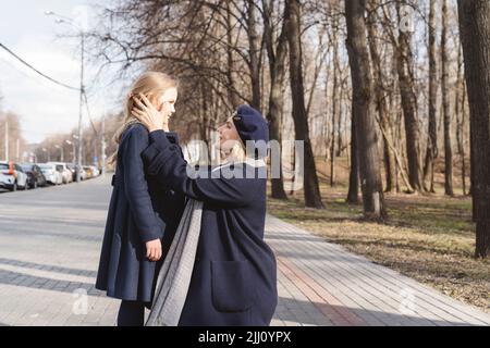 Mamma sta parlando con la figlia in città. Foto Stock