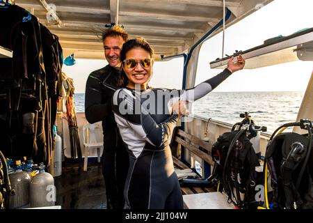 La coppia si prepara per un'immersione su un'imbarcazione di ricerca alla barriera corallina di Tubbataha Foto Stock