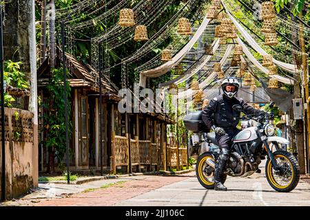 Uomo che guida la sua moto classica nel nord della Thailandia Foto Stock