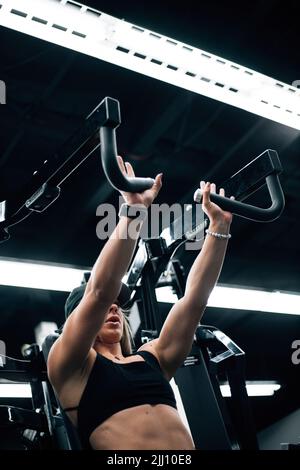 giovane donna adulta che si allena in palestra con reggiseno sportivo nero Foto Stock