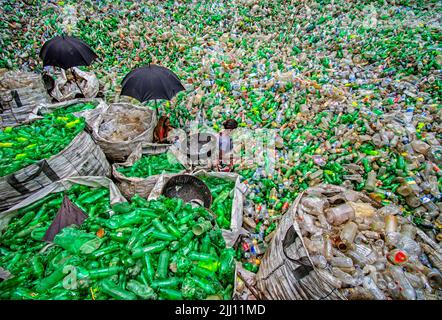 Lavoratori che selezionano a mano bottiglie di plastica in un impianto di riciclaggio, Bogura Bangladesh. Rifiuti di plastica, riutilizzo, industria verde, manodopera, pulizia, sostenibilità Foto Stock