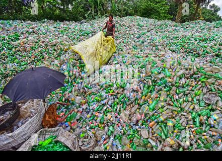 Lavoratori che selezionano a mano bottiglie di plastica in un impianto di riciclaggio, Bogura Bangladesh. Rifiuti di plastica, riutilizzo, industria verde, manodopera, pulizia, sostenibilità Foto Stock