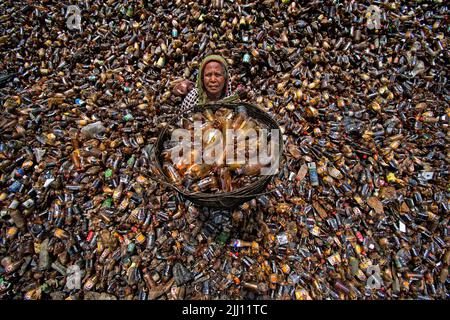 Lavoratori che selezionano a mano bottiglie di plastica in un impianto di riciclaggio, Bogura Bangladesh. Rifiuti di plastica, riutilizzo, industria verde, manodopera, pulizia, sostenibilità Foto Stock