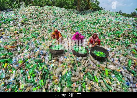 Lavoratori che selezionano a mano bottiglie di plastica in un impianto di riciclaggio, Bogura Bangladesh. Rifiuti di plastica, riutilizzo, industria verde, manodopera, pulizia, sostenibilità Foto Stock