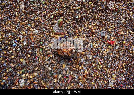 Lavoratori che selezionano a mano bottiglie di plastica in un impianto di riciclaggio, Bogura Bangladesh. Rifiuti di plastica, riutilizzo, industria verde, manodopera, pulizia, sostenibilità Foto Stock