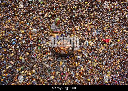 Lavoratori che selezionano a mano bottiglie di plastica in un impianto di riciclaggio, Bogura Bangladesh. Rifiuti di plastica, riutilizzo, industria verde, manodopera, pulizia, sostenibilità Foto Stock