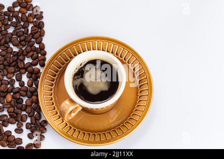 tazza di caffè nero caldo appena fatto e chicchi di caffè su sfondo bianco con spazio per la copia. fuoco selettivo, card per bar, caffetteria, pasticceria Foto Stock