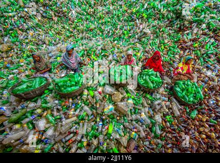 Lavoratori che selezionano a mano bottiglie di plastica in un impianto di riciclaggio, Bogura Bangladesh. Rifiuti di plastica, riutilizzo, industria verde, manodopera, pulizia, sostenibilità Foto Stock