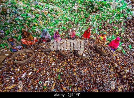 Lavoratori che selezionano a mano bottiglie di plastica in un impianto di riciclaggio, Bogura Bangladesh. Rifiuti di plastica, riutilizzo, industria verde, manodopera, pulizia, sostenibilità Foto Stock