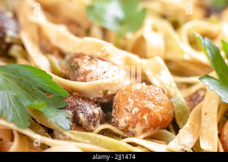 Fettuccine italiane fatte in casa con funghi e salsa cremosa - Fettuccine al funghi Porcini. Cucina italiana tradizionale. Servito su un tavolo scuro Foto Stock