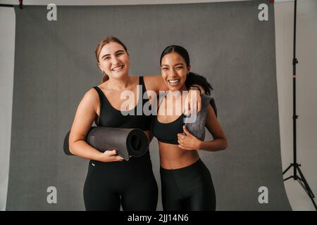 Due amici si preparano ad allenarsi per lo yoga Foto Stock