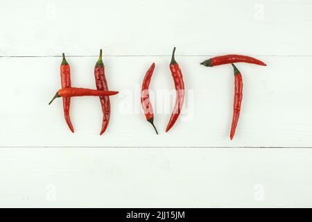 rosso peperoncino molto caldo che ortografia la parola 'caldo' su sfondo bianco Foto Stock