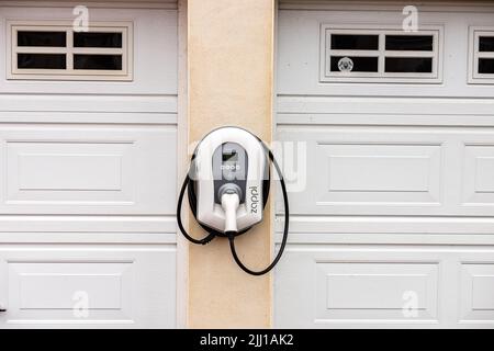 Vista esterna di un wallpod adattivo Zappi Smart EV montato a parete, di un veicolo elettrico o di un punto di ricarica ibrido plug-in per un edificio residenziale Foto Stock