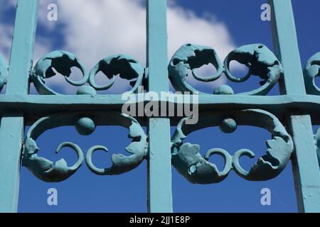 Dettagli del cancello in ferro battuto al castello di Bad Homburg contro il cielo blu. Un'opera d'arte spesso dipinta sopra. Bel gioco di colori e ombre. Foto Stock