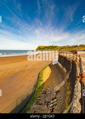 Spiaggia Bandiera Blu di North Bay con le rovine della scogliera del Castello di Scarborough in lontananza. Scarborough, Regno Unito. Foto Stock
