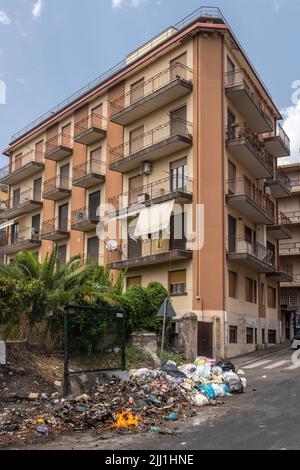 Rifiuti domestici che bruciano per strada a Catania, Sicilia, Italia. Lo smaltimento corretto dei rifiuti è un problema enorme nella città e in gran parte della Sicilia Foto Stock