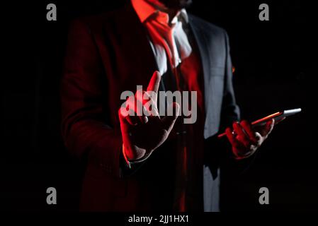 Businessman che tiene il tablet e punta con un dito sul messaggio importante. Executive in Suit che presenta informazioni Crociere. Gentleman mostrando Foto Stock