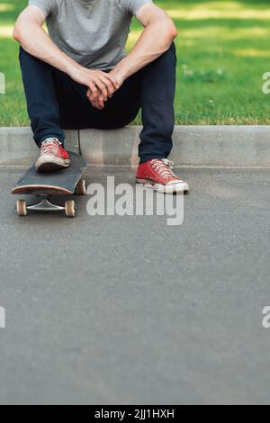 Un hipster uomo irriconoscibile con skateboard Foto Stock