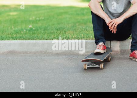 Un hipster uomo irriconoscibile con skateboard Foto Stock