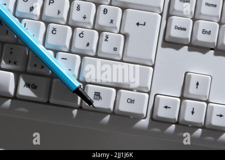 Messaggi importanti scritti sui pulsanti della tastiera con la penna posizionata tra di essi. Informazioni crociate presentate su PC Keys. Annunci critici Foto Stock