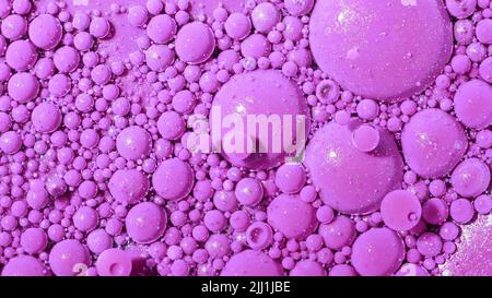 Vista dall'alto abstract delle bolle rosa nella vernice. Inchiostri, sfere, olio. Forme colorate. Sfondo dettagliato, bellissimo design, texture bollature. Foto Stock