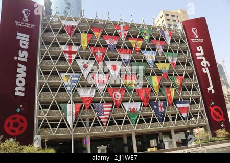 Le bandiere di tutte le 32 nazioni partecipanti sono esposte sulla facciata di un edificio per la celebrazione FIFA 2022. Sarà la migliore coppa del mondo mai organisizzata Foto Stock