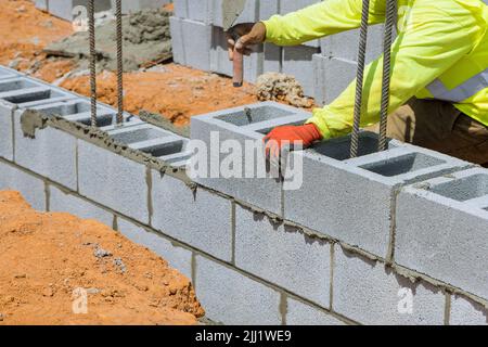 Mason sta posando una parete di blocchi di calcestruzzo cellulare nel processo di montaggio Foto Stock