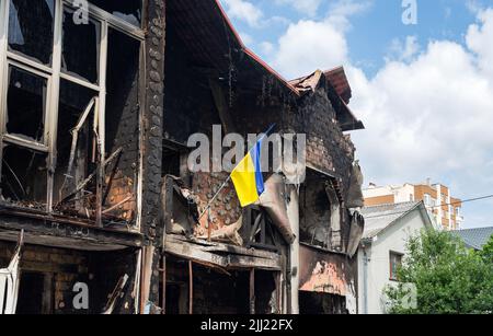 Casa con bandiera Ucraina distrutta dalle armi russe. Atrocità dell'esercito russo nella periferia di Kyiv (Irpin): La guerra della russia contro l'Ucraina. Foto Stock