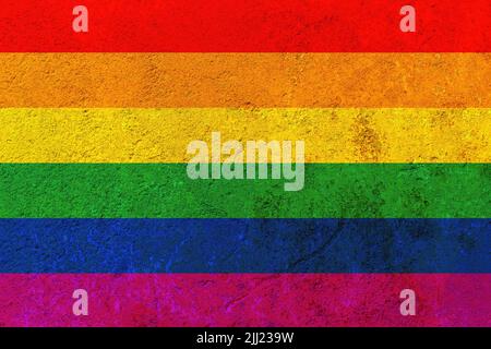 Bandiera arcobaleno contro un muro di ferro arrugginito. Bandiera LGBT dipinta su un muro di ferro arrugginito. Foto Stock