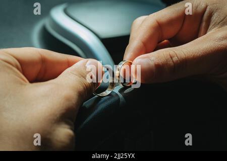 Cerimonia festiva di nozze, lo sposo tiene gli anelli di nozze nelle sue mani. Foto Stock