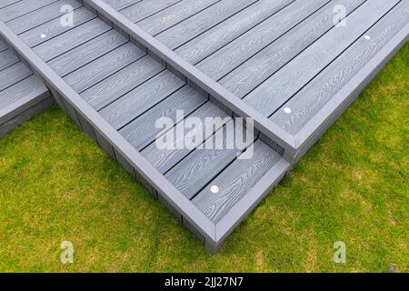 Coperta composita grigio cenere costruita su due livelli su un giardino residenziale posteriore con luci di piattaforma a bassa tensione installato pure. Buona immagine per un paesaggio Foto Stock