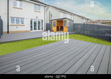 Coperta composita grigio cenere costruita su due livelli su un giardino residenziale posteriore con luci di piattaforma a bassa tensione installato pure. Buona immagine per un paesaggio Foto Stock