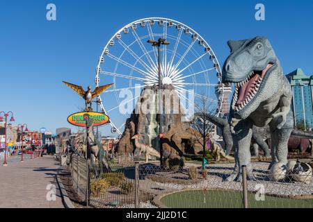 Centro città di Niagara Falls, zona divertimenti Clifton Hill. Dinosaur Adventure Golf. Ruota panoramica SkyWheel. Foto Stock