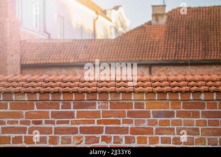 Frammento del tetto rosso. Piastrelle di argilla in un vecchio edificio. Parte superiore di un vecchio edificio piastrellato Foto Stock