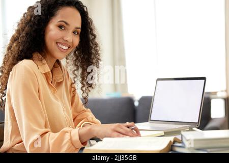 Raccogliendo nuove abilità. Una bella giovane donna che studia da casa. Foto Stock