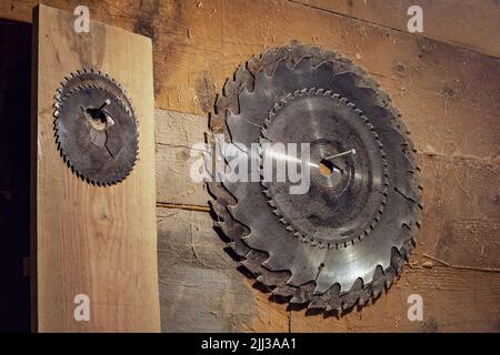 set di lame per sega circolare appeso su una parete di legno nell'officina di carpenteria. Sega circolare. Vecchia Falegnameria rustica officina. Foto Stock