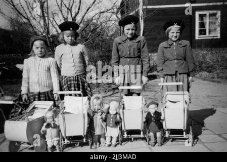 Quattro ragazze con bambole e carrelli. "Ora li abbiamo almeno avviati, ma lo è anche la primavera. 1950' Gittan Gustavsson con le sue amiche, da sinistra: Margareta, Gittan, Ingegerd e Ingrid. (Le foto sono state scattate da William Geidne, padre di Gittan). I giocattoli nella foto (carro di bambola, bambola, vestiti di bambola, occhiali da sole) sono stati consegnati al museo, vedi voce Ölm 38701: 1-12. Il donatore ha preso il carrello della bambola e la bambola quando aveva 5 anni e ha giocato con loro per 7 anni. Sua madre, Nanny Geidne (1910-1997) Örebro, abiti da bambola cuciti, uncinati e lavorati a maglia. Foto Stock